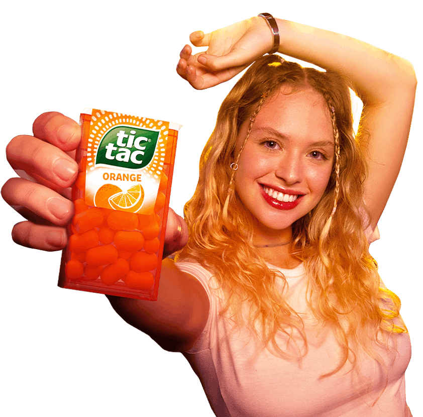 Grafika Tic Tac® Refresh Your Summer przedstawiająca młodą, uśmiechniętą dziewczynę, trzymającą paczkę Orange Tic Tac®